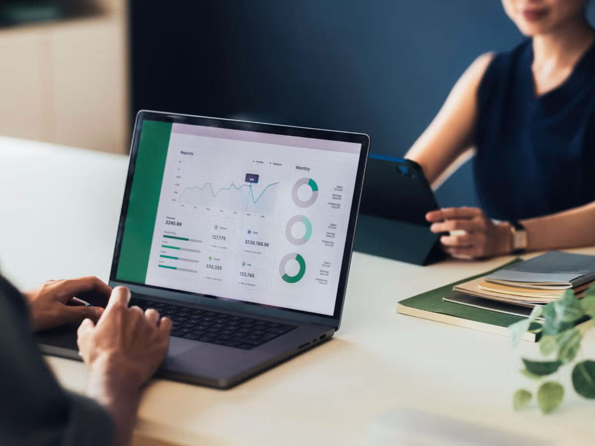 Two people reviewing ESG metrics on a laptop