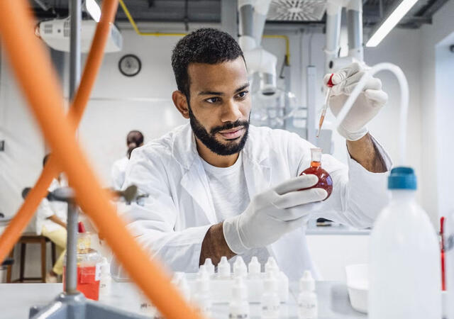 Chemist inspecting liquid in a flask