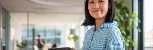 a smiling person working on a tablet