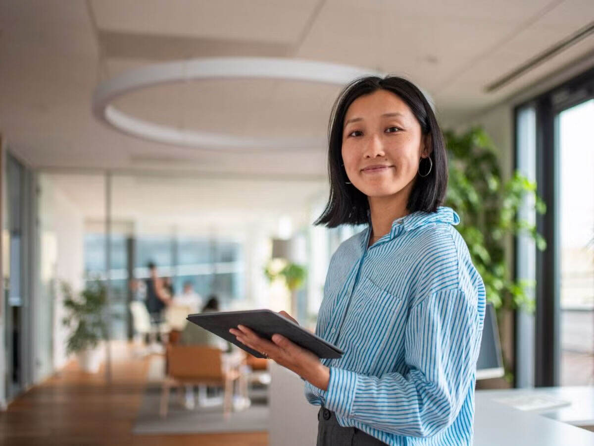 a smiling person working on a tablet