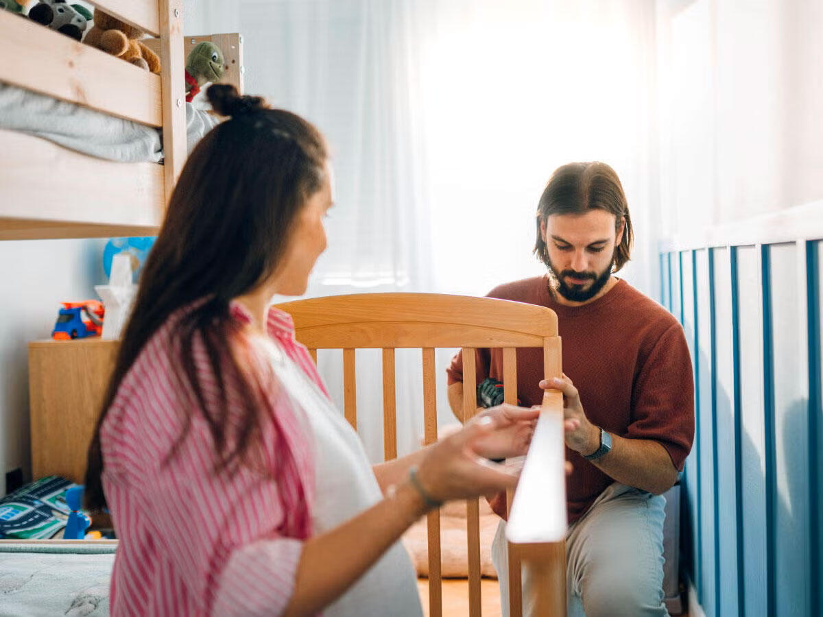 Two people building a crib