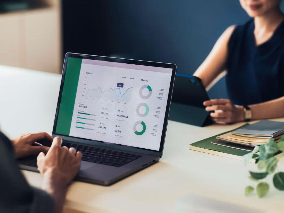 Two people reviewing ESG metrics on a laptop